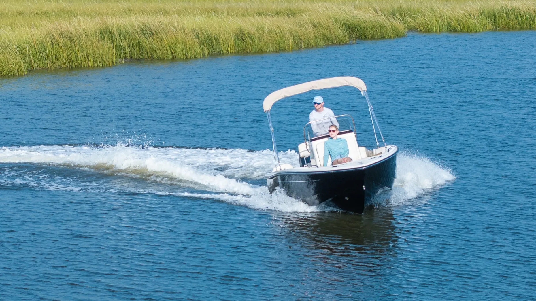 A driver making a sharp turn on a lake in a new Scout Boat 188 SF center console boat